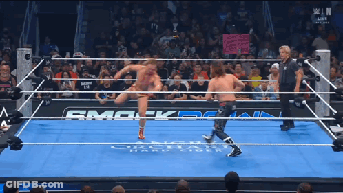 Two Wrestlers In Ring With Smack Down Sign GIF