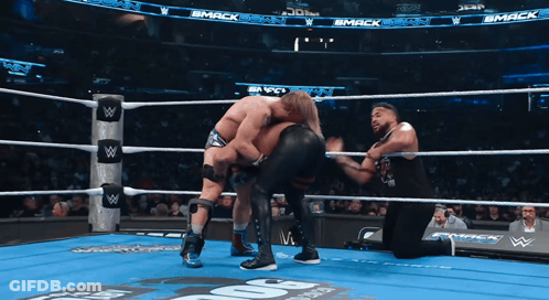 Two Wrestlers In Ring With Smack Sign GIF
