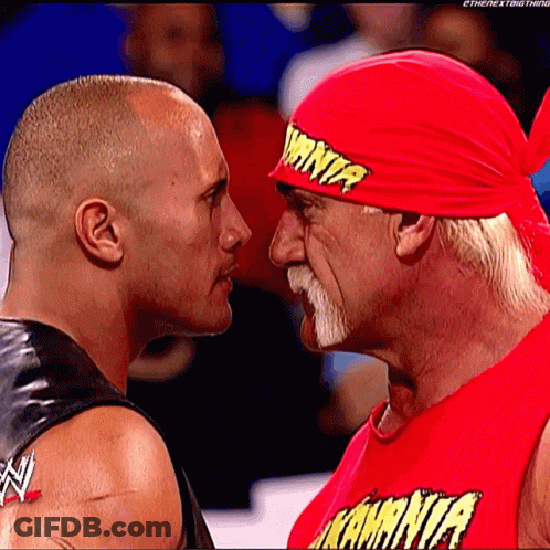 Two Wrestlers Looking At Each Other With One Wearing A Red Shirt That Says ' Kamina ' GIF
