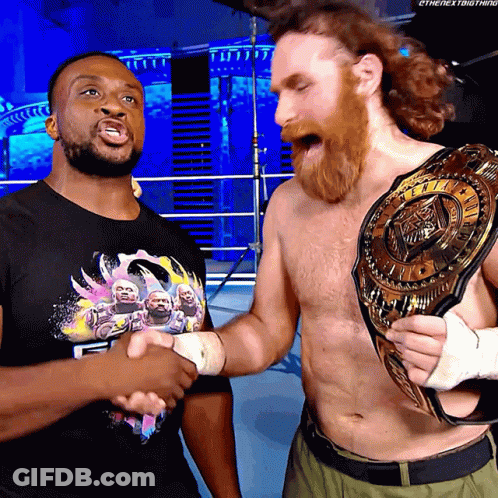 Two Wrestlers Shaking Hands With One Wearing A T-Shirt That Says ' Ethenextbigthing ' On It GIF
