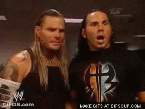 Two Wrestlers Standing In Dark Room Looking At Each Other GIF