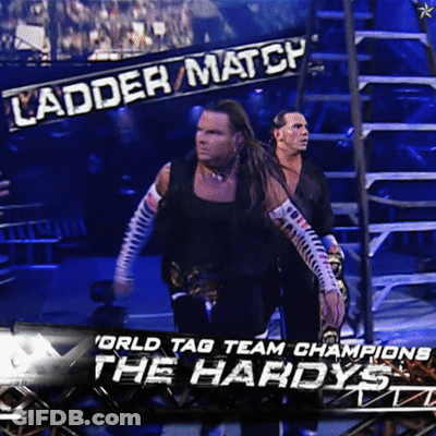 Two Wrestlers Standing In Front Of Ladder Match Banner GIF
