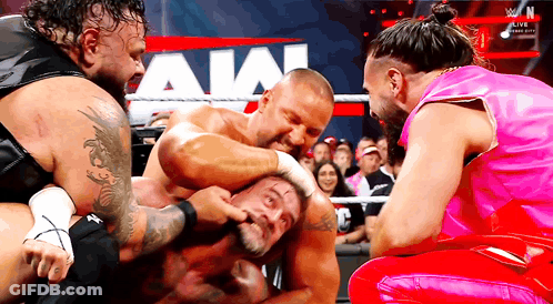 Two Wrestlers Standing In Front Of WWE Sign GIF