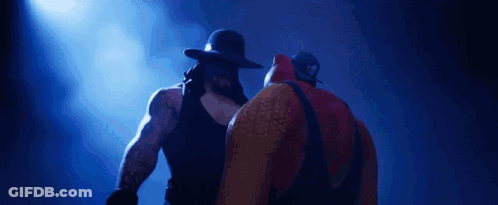 Two Wrestlers Standing Next To Each Other GIF