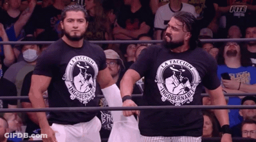 Two Wrestlers Wearing Black Shirts That Say La Facción GIF