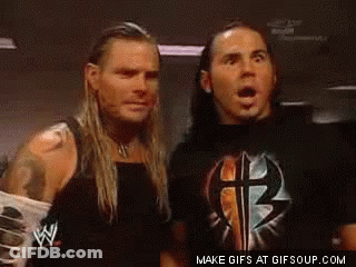 Two Wrestlers With Mouths Open In Dark Room GIF