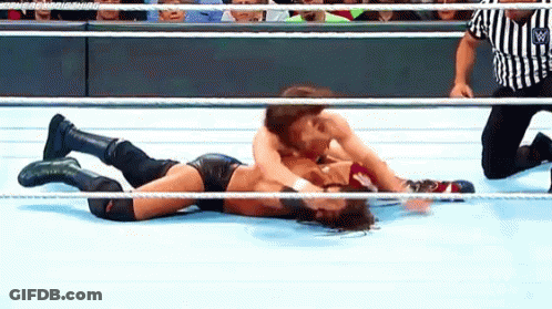 Two Wrestlers Wrestling In Ring With Referee GIF