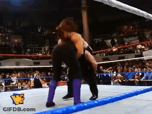 Two Wrestlers Wrestling In Ring With W Logo GIF