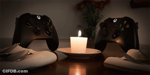 Two Xbox Controllers Next To Lit Candle GIF