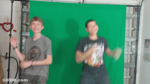 Two Young Boys Are Dancing In Front Of A Green Screen GIF