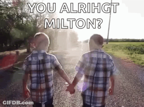 Two Young Boys Are Holding Hands On A Gravel Road . GIF