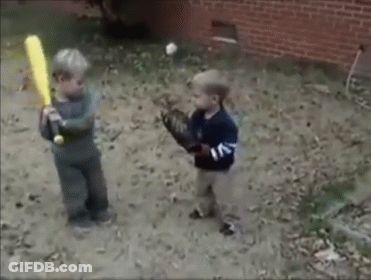 Two Young Boys Are Playing Baseball In The Dirt And One Is Holding A Bat GIF