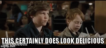 Two Young Boys Are Sitting At A Table In A Restaurant And Eating . GIF