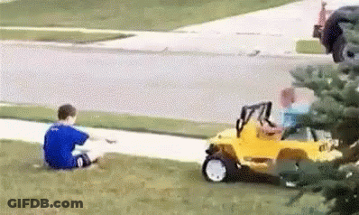 Two Young Boys Are Sitting On The Grass Next To A Yellow Toy Car . GIF