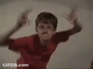 Two Young Boys Are Standing Next To Each Other In A Room . GIF