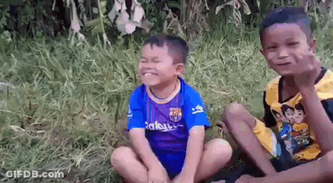 Two Young Boys Sitting On Grass GIF