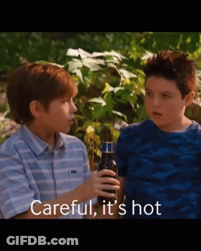 Two Young Boys Standing Next To Each Other With One Holding A Bottle Of Beer And The Words Careful It 'S Hot Above Them GIF