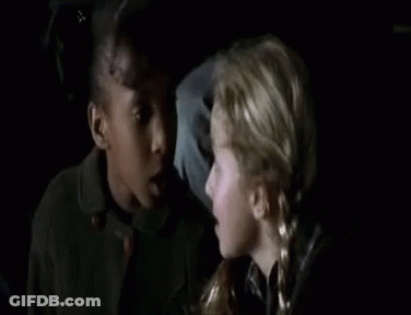 Two Young Girls Sitting Next To Each Other In Dark Room GIF