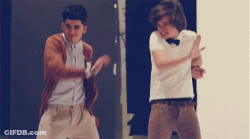 Two Young Men Are Dancing Together In Front Of A Door . GIF