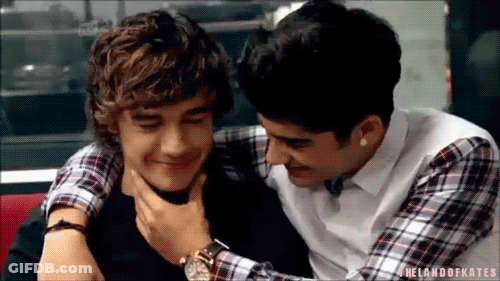 Two Young Men Are Hugging Each Other In A Restaurant And One Of Them Is Holding The Other 'S Neck . GIF