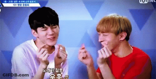 Two Young Men Are Making Heart Shaped Fingers With Their Hands . GIF