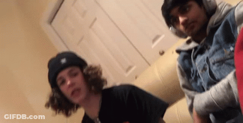 Two Young Men Are Posing For A Picture Together In A Room . GIF