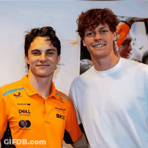 Two Young Men Are Posing For A Picture With One Wearing An Orange Shirt That Says Dell GIF