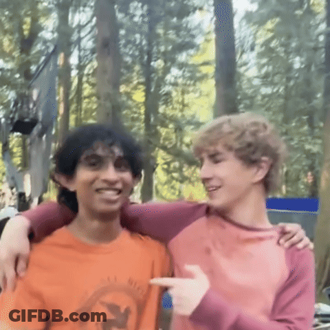 Two Young Men Are Posing For A Picture With One Wearing An Orange Shirt That Says Eagle GIF