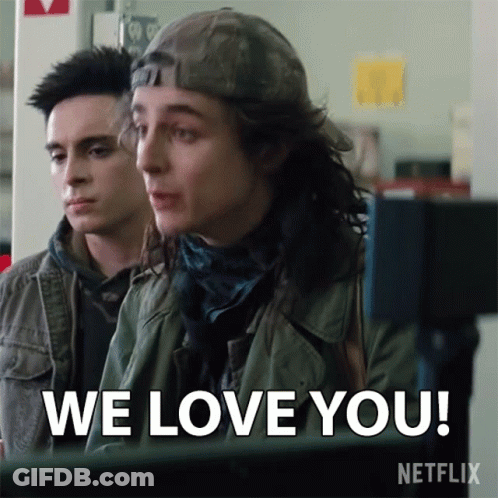 Two Young Men Are Sitting In Front Of A Computer And One Of Them Says We Love You GIF