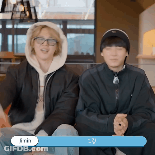 Two Young Men Are Sitting Next To Each Other And One Of Them Has The Name Jimin On The Bottom GIF