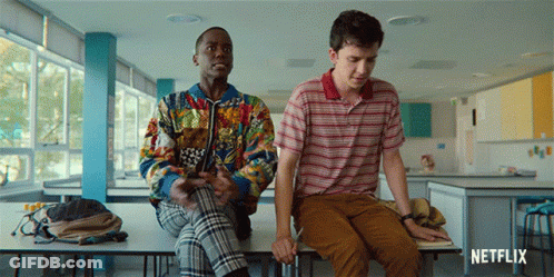 Two Young Men Are Sitting On A Table With A Netflix Logo In The Corner GIF