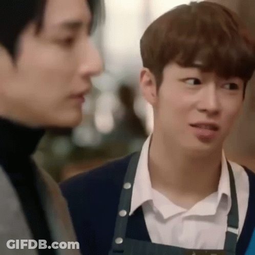 Two Young Men Are Standing Next To Each Other In A Restaurant . GIF