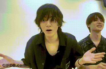 Two Young Men Are Standing Next To Each Other In A Room And One Of Them Is Making A Funny Face . GIF
