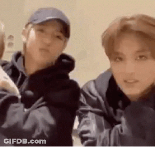 Two Young Men Are Standing Next To Each Other In A Room . One Of The Men Is Wearing A Baseball Cap . GIF