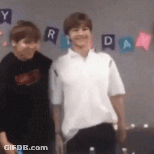 Two Young Men Are Standing Next To Each Other In A Room . One Of The Men Is Wearing A White Shirt . GIF