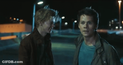 Two Young Men Are Standing Next To Each Other In The Dark GIF