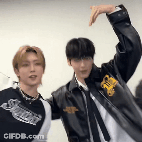 Two Young Men Are Standing Next To Each Other With Their Arms Outstretched . GIF
