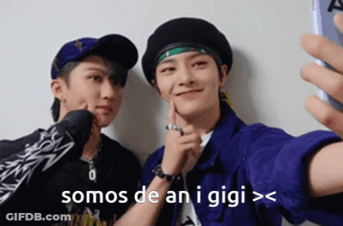 Two Young Men Are Taking A Selfie With A Cell Phone And The Words Somos De An I Gigi GIF