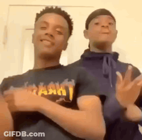 Two Young Men Dancing Next To Each Other GIF