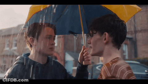 Two Young Men Holding Umbrella In Rain GIF