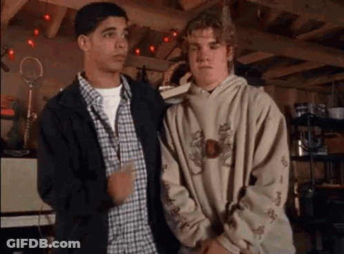 Two Young Men In Garage, One In Hoodie GIF
