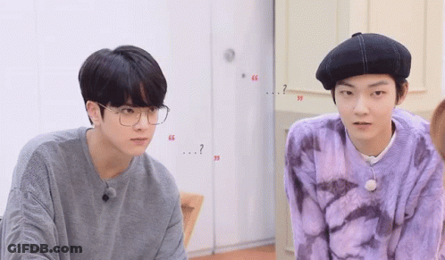 Two Young Men In Glasses And Berets Talking GIF