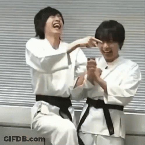 Two Young Men In Karate Uniforms Laughing Together GIF
