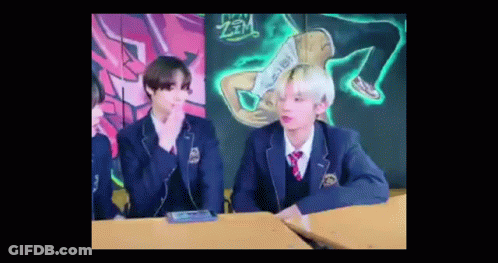 Two Young Men In School Uniforms At Desk GIF