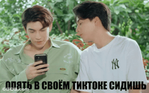 Two Young Men Looking At Cell Phone With Foreign Caption GIF