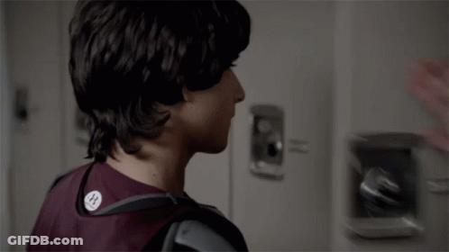 Two Young Men Looking At Each Other In Locker Room GIF