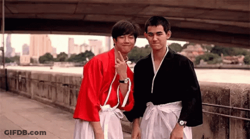 Two Young Men On Sidewalk One In Red Kimono GIF