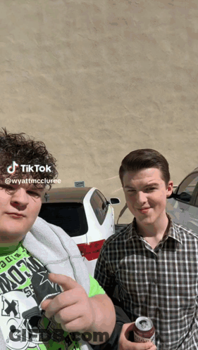 Two Young Men Posing For Photo GIF