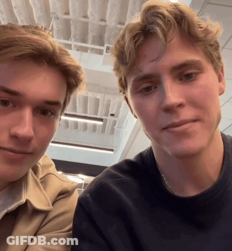 Two Young Men Posing, One Wearing Chain GIF