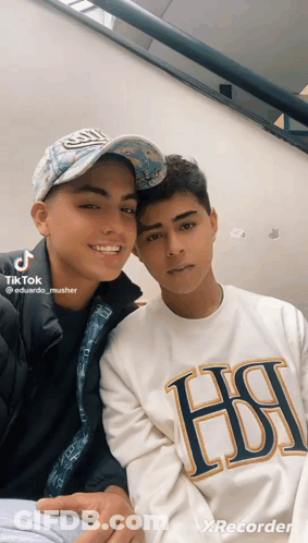 Two Young Men Posing One Wearing HSI Shirt GIF